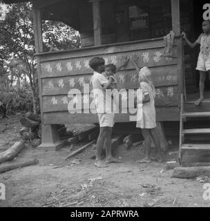 Journey to Suriname and the Netherlands Antilles  A Hindu family makes a handprint on a home of a farm worker where a marriage will take place in the Commewijnegebid in Suriname. The white dye consists of ground rice and ginger Date: 1947 Location: Commewijne, Suriname Keywords: Hindus, marriages, homes Stock Photo