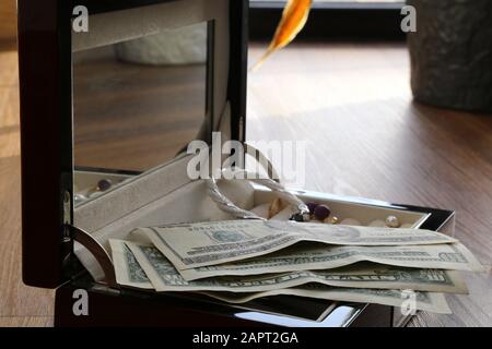 Reflection of box with money and jewelry equally valuable objects Stock Photo