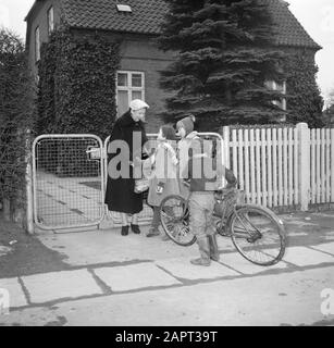 Visit to Prime Minister Hedtoft and his family  Ella Hedtoft greets children in front of the gate of the garden Date: March 1954 Location: Denmark, Copenhagen Keywords: bicycles, fences, children, gardens, homes Personal name: Hedtoft, Ella Stock Photo