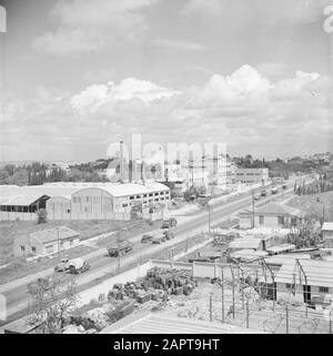 Israel 1948-1949  Buildings of the citrus juice factory Assis on the road from Tel Aviv to Haifa. On the road trucks and lower right new construction of production spaces Date: 1948 Location: Israel Keywords: industrial sites, citrus fruits, factories, fruit growing, industry, trucks, fruit juices Stock Photo