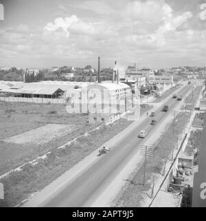 Israel 1948-1949  Buildings of the citrus juice factory Assis on the road from Tel Aviv to Haifa. On the road a.o. a horse and wagon and trucks Date: 1948 Location: Israel Keywords: cars, industrial parks, citrus fruits, factories, fruit growing, industry, trucks, fruit juices Stock Photo