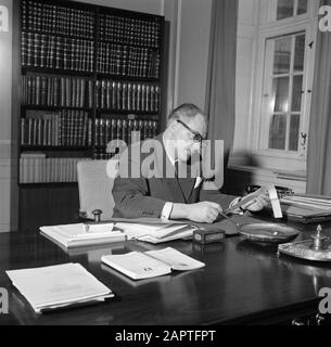 Visit to Prime Minister Hedtoft and his family  Hans Hedtoft behind his desk at the Ministry Date: March 1954 Location: Denmark, Copenhagen Keywords: books, desks, offices, furniture, ministries, ministers-presidents Personal name: Hedtoft, Hans Stock Photo