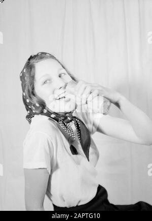 Family photos  Hans pose with kerchief, sandwich in hand Annotation: Regina (nickname Hans) was a stepdaughter of photographer Willem van de Poll Date: June 1936 Keywords: bread, headscarves, etc. portraits, women Stock Photo