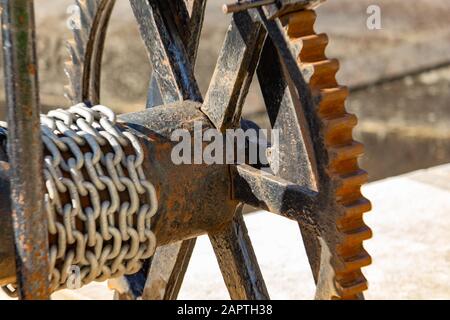 A rusty metal crab winch, used by hand for controlling the lock doors at a lock station is viewed up close, showing its detailed wheel. Stock Photo