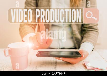 Handwriting text Video Production. Conceptual photo process of converting an idea into a video Filmaking Business woman sitting with mobile phone and Stock Photo