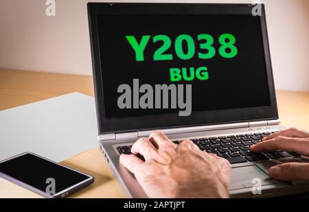 Man hands typing on a laptop in text code. Year 2038 problem concept Stock Photo