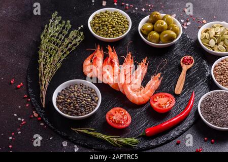 Fine selection of jumbo shrimps for dinner on stone plate. Food background Stock Photo