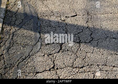 Cracks of asphalt close up. Street texture. Stock Photo