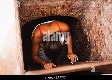 Girl climbing down ladder of an old building. Stock Photo