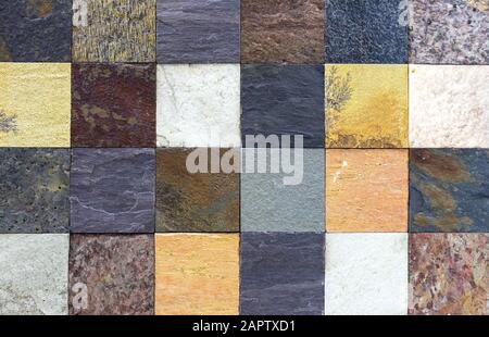 Multi-colored squares from of natural stone for room decor. Blocks made of natural stone. Background of rough stone. Stock Photo