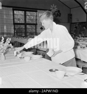 Israel 1964-1965: Gal'ed, since evening  Boy puts napkins on the table for the celebration of Seiderdiner Annotation: Gal'ed (also called Even Yitzhak) is a kibbutz in the north of Israel, located in the plain of Manasseh. In 2006 it had a population of 405. Seder Evening (also called Seideravond) is an evening at the beginning of the Passover festival, where Jews from the Haggada read (booklet about the story of Jewish slavery in Egypt and the exodus from Egypt), drink 4 glasses of wine (or grape juice) and a festive sedermeal. Seder literally means order or order, because the customs are per Stock Photo