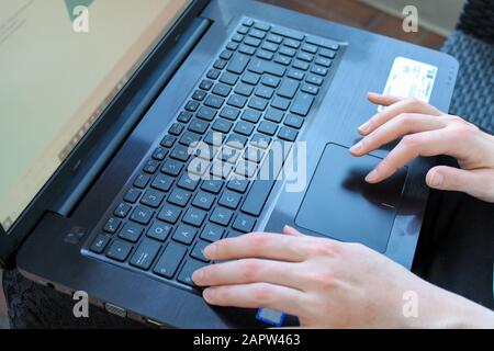 Female hands typing and clicking shift on black laptop close-up Stock Photo