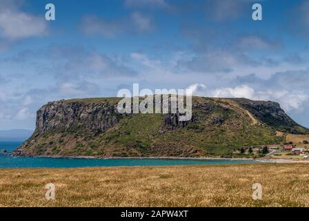 Stanley, Tasmania, Australia - December 15, 2009: Closeup of The Nut volcanic plug and nothing else under blue cloudscape.  green meadow in front. Stock Photo