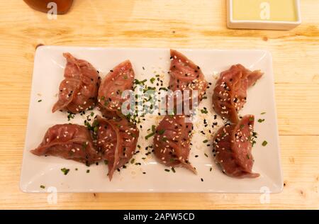 Two bottles of soy sauce and hot chili with red meat, shrimps and mushroom dumplings Stock Photo