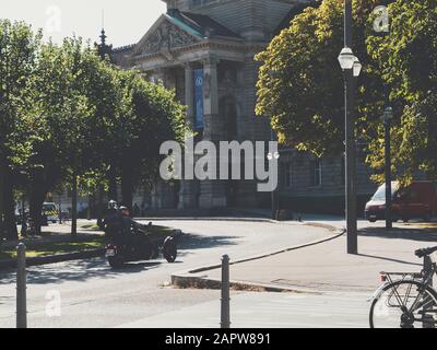 Strasbourg, France - Sep 21, 2019: Two men on motorcycle driving near Palais Du Rhin in central Strasbourg Stock Photo