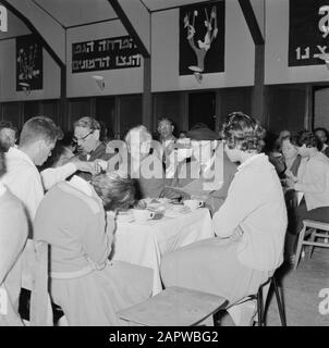 Israel 1964-1965: Gal'ed, since evening  Members of the kibbutz Gal'ed celebrate in the community space Seideravond. The oldest at the table says a blessing spell during the seder meal after which a drink of wine is drunk Annotation: Gal'ed (also called Even Yitzhak) is a kibbutz in northern Israel, located in the plain of Manasseh. In 2006 it had a population of 405. Seder Evening (also called Seideravond) is an evening at the beginning of the Passover festival, where Jews from the Haggada read (booklet about the story of Jewish slavery in Egypt and the exodus from Egypt), drink 4 glasses of Stock Photo