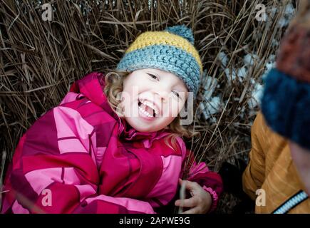 portrait of young girl laying on the ground laughing looking Stock Photo