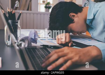 A young businessman who works hard and sleeps at his desk. Stock Photo