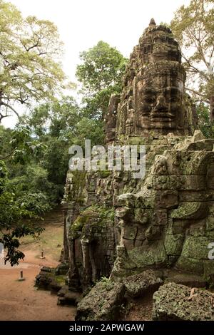 Human face carved on top of ancient gate in Angkor Stock Photo