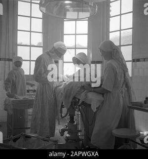 War volunteers in Malacca and Indonesia  Medical operation in Bandoeng Date: April 1, 1946 Location: Bandung, Indonesia, Dutch East Indies Keywords: surgeons, operating rooms, operations, nurses, hospitals Stock Photo