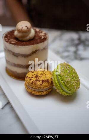 Closeup shot of two macaroon biscuits  and a small cake Stock Photo