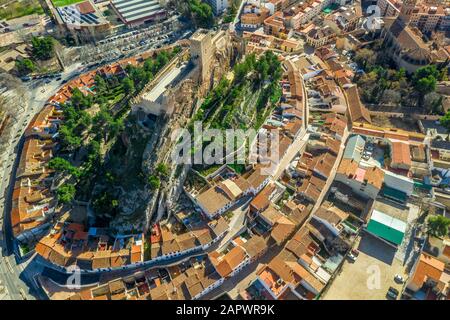 Aerial view of medieval Almansa castle with donjon and courtyard on a rock emerging from the plateau surrounded by a circular ring of red roof houses Stock Photo