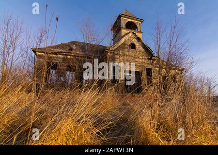 Old abandoned schoolhouse in the Midwest at sunrise. Stock Photo