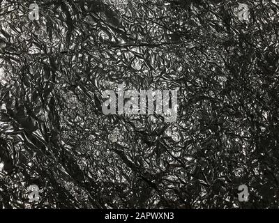 Dark gray and black color rumpled paper foil texture background. Stock Photo
