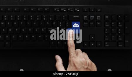 Cloud computing and cloud storage technology. Hand pressing cloud icon on computer keyboard Stock Photo