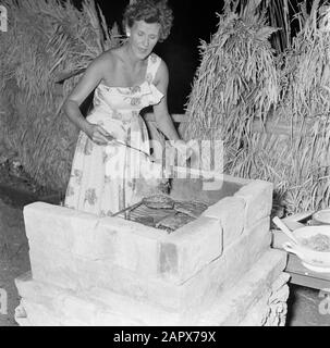 Dutch Antilles and Suriname at the time of the royal visit of Queen Juliana and Prince Bernhard in 1955  Straw barbecuing Date: 1 October 1955 Location: Curaçao, Netherlands Antilles Keywords: meals, women Stock Photo