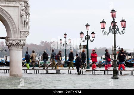 Flooded St. Mark's Square, people on jetties in motion, Venice, Italy Stock Photo