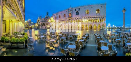 Restaurant at St. Mark's Square with Doge's Palace at night, flooded because of high water, panorama, Venice, Italy Stock Photo