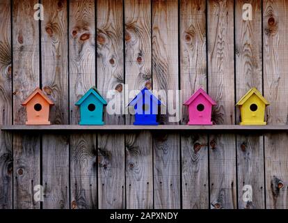 Colorful birdhouses on a barn wall Stock Photo