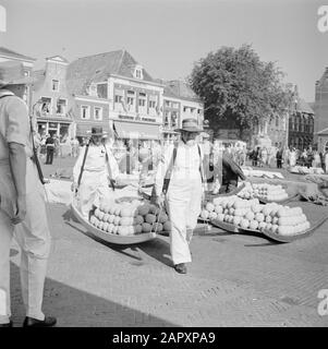 Cheese market in Alkmaar  Two cheese carriers carry the cheeses on a berrie Date: 1 January 1959 Location: Alkmaar, Noord-Holland Institution name: Waag, The Stock Photo