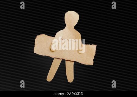 Paper man shape holding burnt note paper in hand Stock Photo