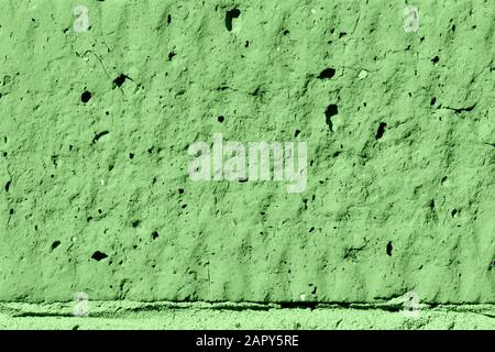 Brick wall texture close-up lit by the sun. Abstract background green color toned Stock Photo