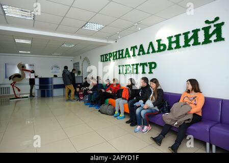 People, pregnant women and relatives, sitting in chairs waiting in a reception hall of a maternity hospital. April 12, 2019. Kiev, Ukraine Stock Photo