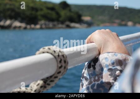 Closeup shot of a woman's hand holding on the metal bar with a blurred background Stock Photo