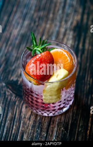 Fruit Cocktail with Strawberry, Mandarin, Apple and Rosemary / Fresh Pink Punch Beverage. Summer Drink. Stock Photo