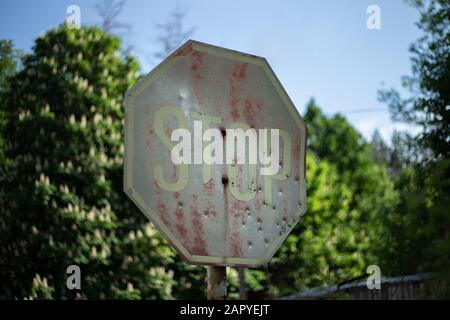 Old rusty stop roadsign in Chornobyl exclusion zone Stock Photo