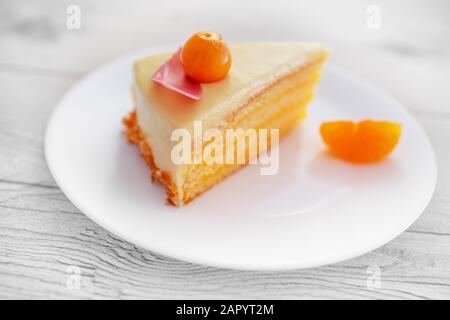 Chocolate cake with physalis fruits, cream, nuts on a plate over wooden background Stock Photo