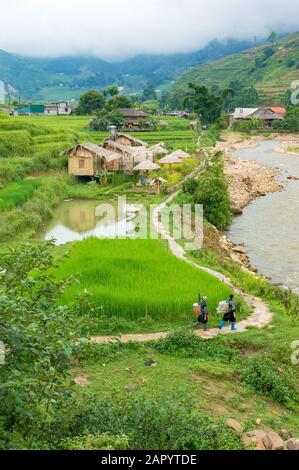 SaPa, Vietnam - August 16, 2017: Aerial view of Vietnamese countryside landscape with two local women walking the road Stock Photo
