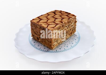 Cake piece with nuts and chocolate on a plate isolated on white background Stock Photo