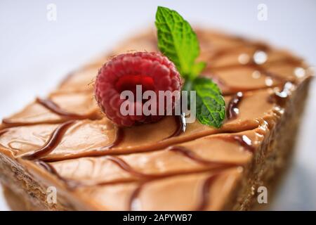 Cake piece chocolate with milk cream and fruits isolated on black background. Stock Photo
