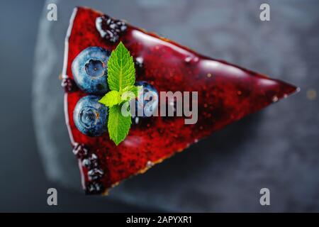 Cake with berry fruits, chia cereals and nuts isolated on black background. Stock Photo