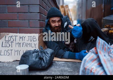 Bearded beggar sleeping on city street Stock Photo
