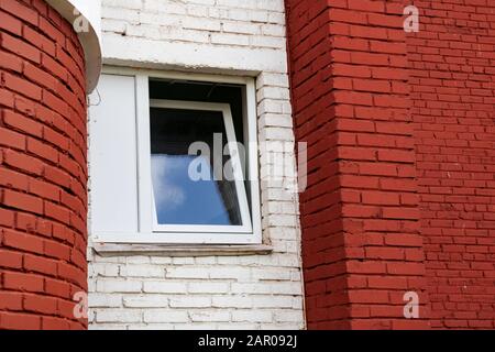Plastic window on the wall of a red brick house Stock Photo