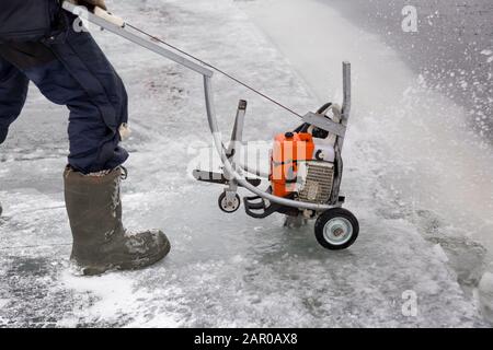 Sawing machine on the ice of a frozen lake Stock Photo