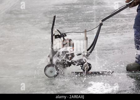 Sawing machine on the ice of a frozen lake Stock Photo