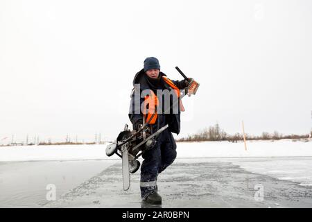 Sawing machine on the ice of a frozen lake Stock Photo